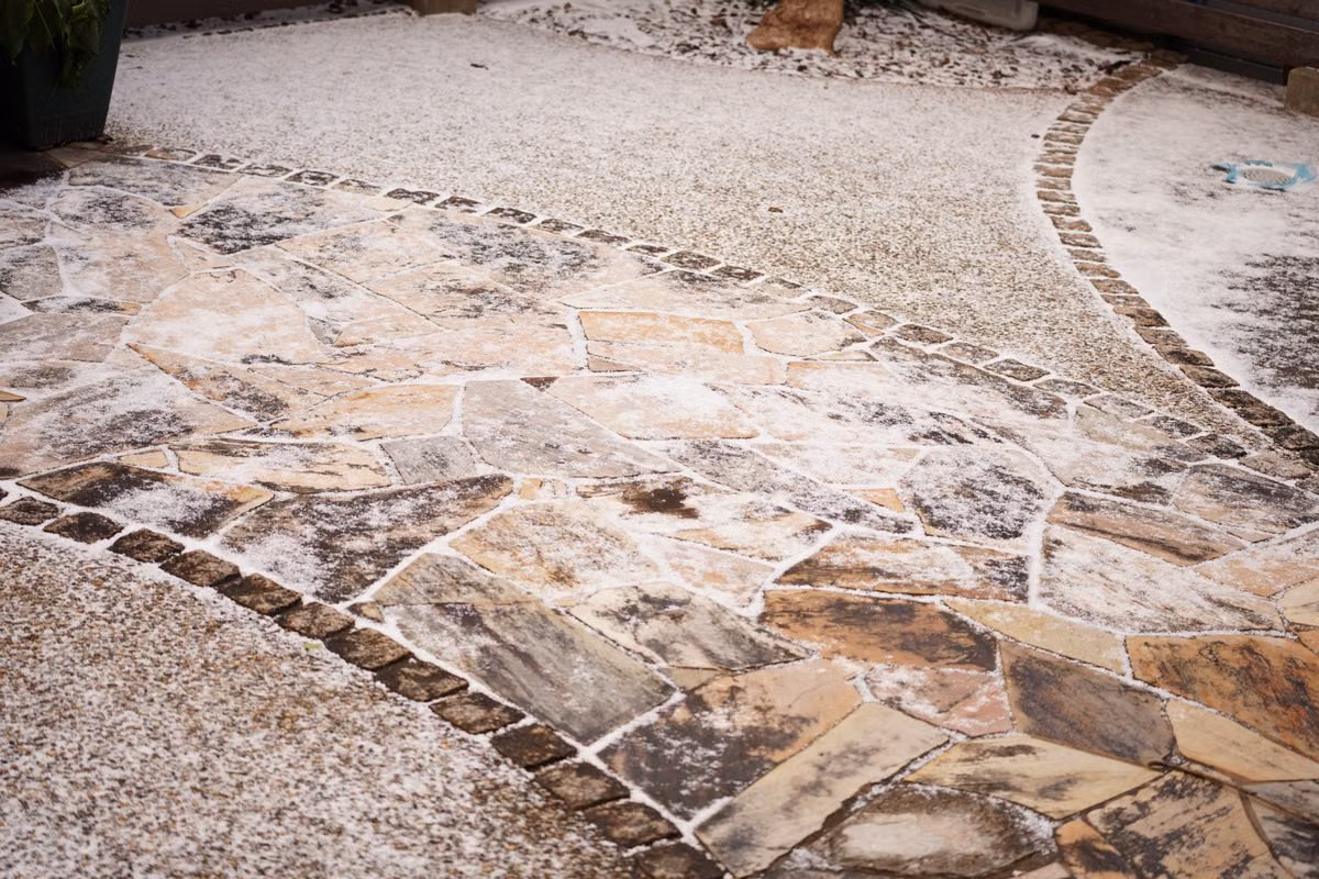 Completed landscape hardscape design with stone patio, planting beds, and clean edging in Wenonah
